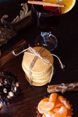 Düz yatak, tatlı kurabiyeler, fındıklı çikolata, tarçın, mandalina ve cam içinde sıcak şarap.