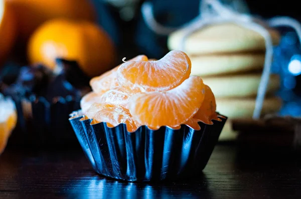 Primer plano rebanadas de mandarina en bandeja para hornear, galletas y chocolate en el fondo, tiempo de Navidad — Foto de Stock