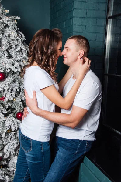 Liebendes Ehepaar kuschelt am Weihnachtsbaum, Fenster — Stockfoto