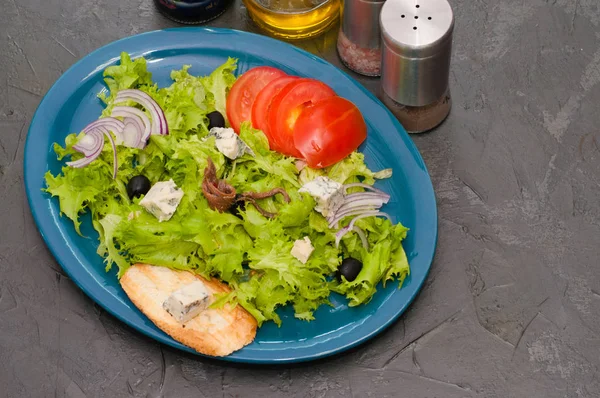 Σαλάτα με χταπόδι ή καλαμάρι, τυρί, ντομάτα, ελιές, κρεμμύδια, μπαχαρικά και κρουτόν, σάλτσα ή λάδι σε μπλε πιάτο, αντίγραφο χώρου. — Φωτογραφία Αρχείου