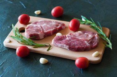 Çiğ domuz bifteği, kırmızı domates, biberiye ve sarımsak.