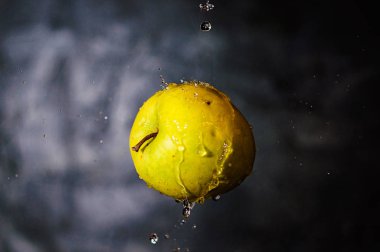 Havada süzülen sarı-yeşil elma damlaları