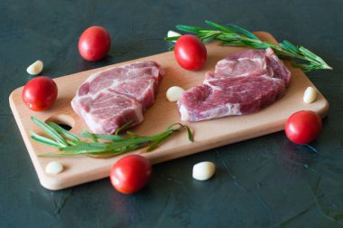 Çiğ domuz bifteği, kırmızı domates, biberiye ve sarımsak.