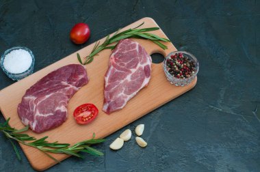 Düz yatak, domuz eti, çiğ biftek ve baharatlar, sarımsak, tuz, biber, dilimlenmiş domates ve biberiye.
