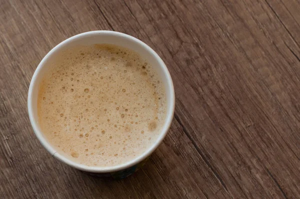 Cappuccino dengan busa lezat dalam cangkir kertas, top view, kopi untuk pergi — Stok Foto