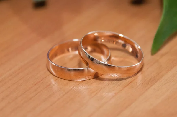 Wedding rings of the bride and groom close-up on wooden surface with a place for text — 스톡 사진