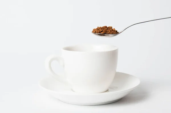 Sendok kopi instan di atas cangkir putih di latar belakang putih — Stok Foto