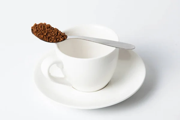 Spoon with instant coffee on a cup on a white background — 스톡 사진