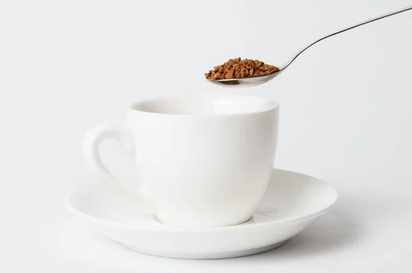 Cuchara de café instantánea sobre taza blanca sobre fondo blanco —  Fotos de Stock