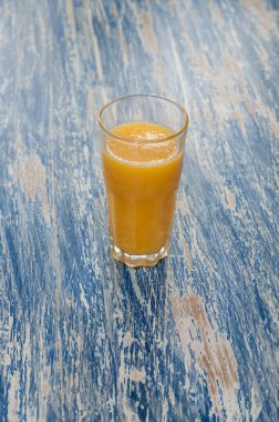 Mavi arka planda portakal suyu bardağı deniz rengi