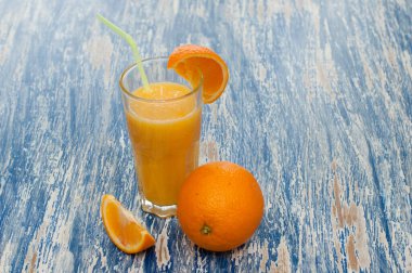 Bir saman ile bir bardak portakal suyu kokteyli
