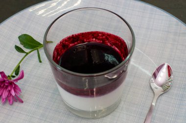 İtalyan şenlikli tatlı Panacotta, dut dolgulu, cam bardakta, kaşıklı, yakın plan.