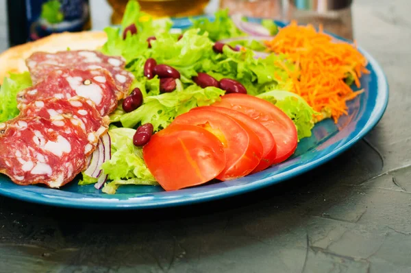 沙律与香肠，西红柿，豆子，胡萝卜，香料，橄榄油或酱油。 提供意大利食品的餐馆 — 图库照片