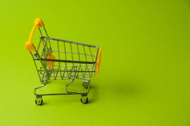 Yeşil arka planda alışveriş için tramvay. Süpermarket fiyat konsepti, tatil indirimleri