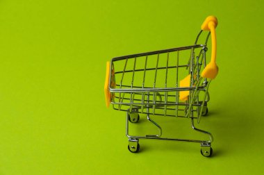 Yeşil arka planda alışveriş için tramvay. Süpermarket fiyat konsepti, tatil indirimleri
