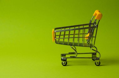 Yeşil arka planda alışveriş için tramvay. Süpermarket fiyat konsepti, tatil indirimleri