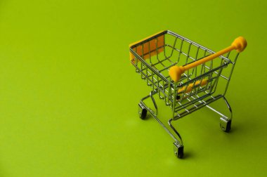 Yeşil arka planda alışveriş için tramvay. Süpermarket fiyat konsepti, tatil indirimleri