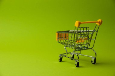 Yeşil arka planda alışveriş için tramvay. Süpermarket fiyat konsepti, tatil indirimleri