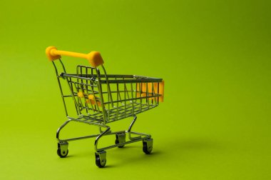 Yeşil arka planda alışveriş için tramvay. Süpermarket fiyat konsepti, tatil indirimleri