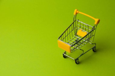 Yeşil arka planda alışveriş için tramvay. Süpermarket fiyat konsepti, tatil indirimleri