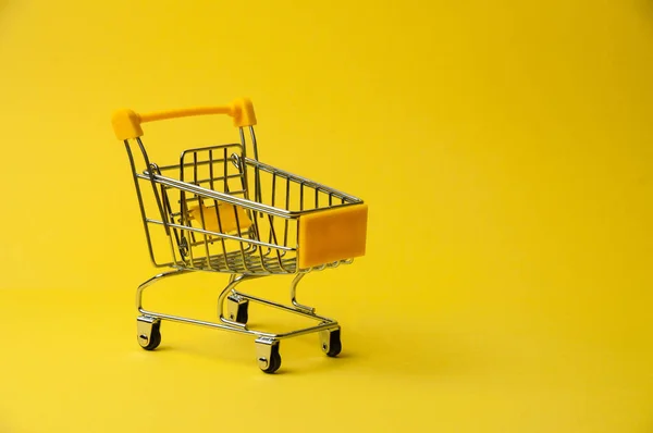 黄色の背景で買い物のためのカート スーパーマーケットフード価格のコンセプト 休日割引 — ストック写真