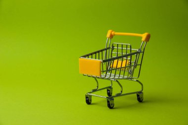 Yeşil arka planda alışveriş için tramvay. Süpermarket fiyat konsepti, tatil indirimleri