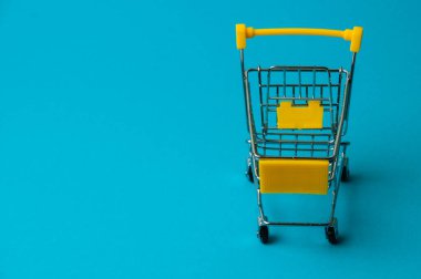 Mavi arka planda alışveriş için tramvay. Süpermarket fiyat konsepti, tatil indirimleri