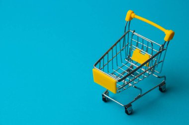 Mavi arka planda alışveriş için tramvay. Süpermarket fiyat konsepti, tatil indirimleri