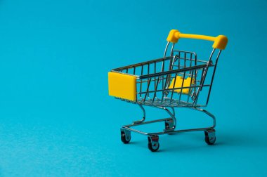 Mavi arka planda alışveriş için tramvay. Süpermarket fiyat konsepti, tatil indirimleri