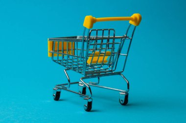 Mavi arka planda alışveriş için tramvay. Süpermarket fiyat konsepti, tatil indirimleri