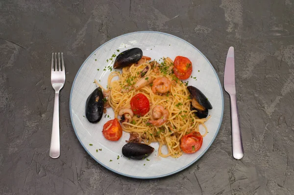 Spaghetti pasta with shrimp, mussels, tomatoes and cheese. Tasty traditional Italian food