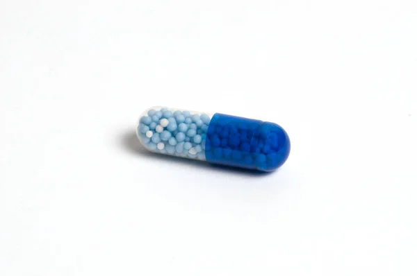 One tablet, vitamin capsule on a white background, isolate. The concept of medicine and protection against coronavirus