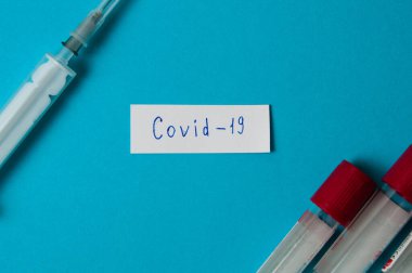 Coronavirus ilaç ve tedavi konsepti. Coronavirus COVID-19 notu. Şırınga, kan testi tüpleri.