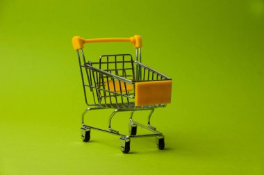 Yeşil arka planda alışveriş için tramvay. Süpermarket fiyat konsepti, tatil indirimleri