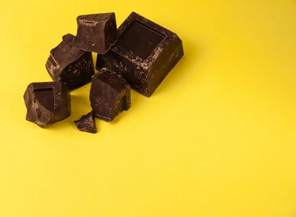 Pedaços Apetitosos Chocolate Preto Isolar Fundo Amarelo Close Espaço Cópia — Fotografia de Stock