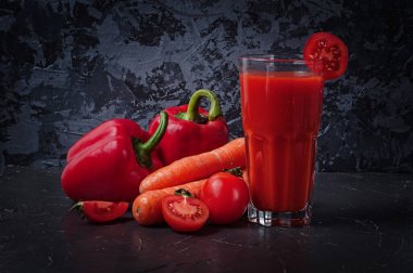 Koyu beton bir yüzeyde meyve suyu dolu sebzeler.