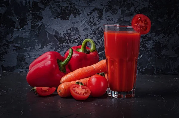 Koyu beton bir yüzeyde meyve suyu dolu sebzeler.