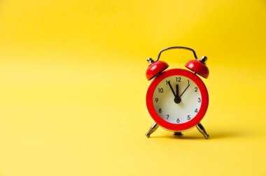 Sarı arkaplanda klasik alarm saati kırmızı
