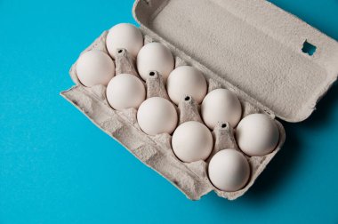 Mavi arka planda bir tepside yumurtalar. Metin için yeri olan kavramsal fotoğraf.