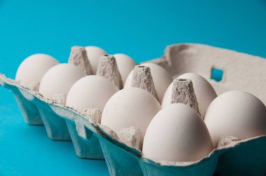 Mavi arka planda bir tepside yumurtalar. Metin için yeri olan kavramsal fotoğraf.