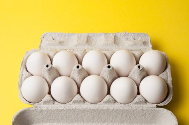 Sarı arka planda bir tepside tavuk yumurtası, boşluğu kopyala