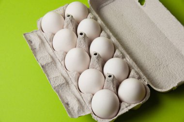 Neon yeşil arka planda açık bir tepside yumurtalar