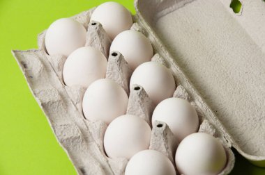 Neon yeşil arka planda açık bir tepside yumurtalar