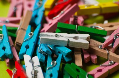 Yeşil arkaplanda çok renkli ahşap mandallar, makro yakın plan, boşluğu kopyala