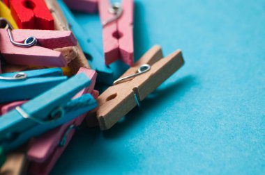 Mavi arkaplanda renkli ahşap mandallar, makro yakın plan, boşluğu kopyala