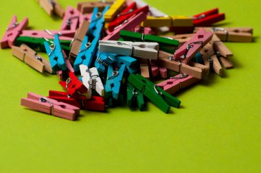 Yeşil arka planda çok renkli ahşap mandallar.