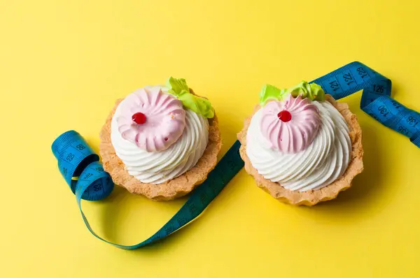 Dois Bolos Centímetro Sobre Fundo Amarelo Conceito Controle Peso Alimentação — Fotografia de Stock