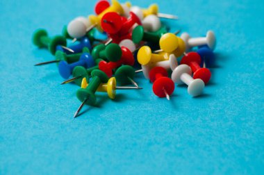 Mavi arkaplan makro yakın plan üzerinde çok renkli itme iğneleri