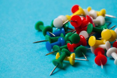 Mavi arkaplan makro yakın plan üzerinde çok renkli itme iğneleri