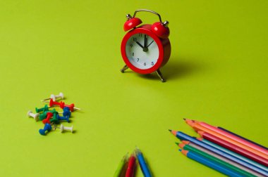 Kalemler, kalemler Yeşil desenli kağıt üzerinde iğne ve saat